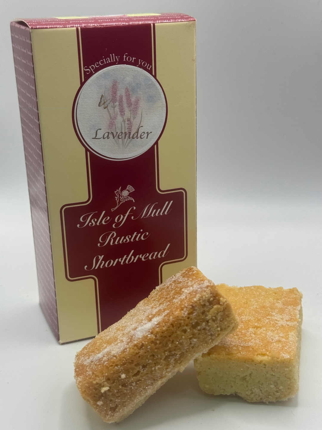 box of tobermory stores handmade lavender shortbread with two delicious pieces of tobermory stores lavender handmade shortbread in the foreground